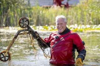 Un plongeur repêche une trottinette dans un étang à l'occasion du Clean-Up-Day. IGSU